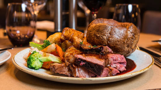 Plate of roast beef, Yorkshire pudding, and vegetables
