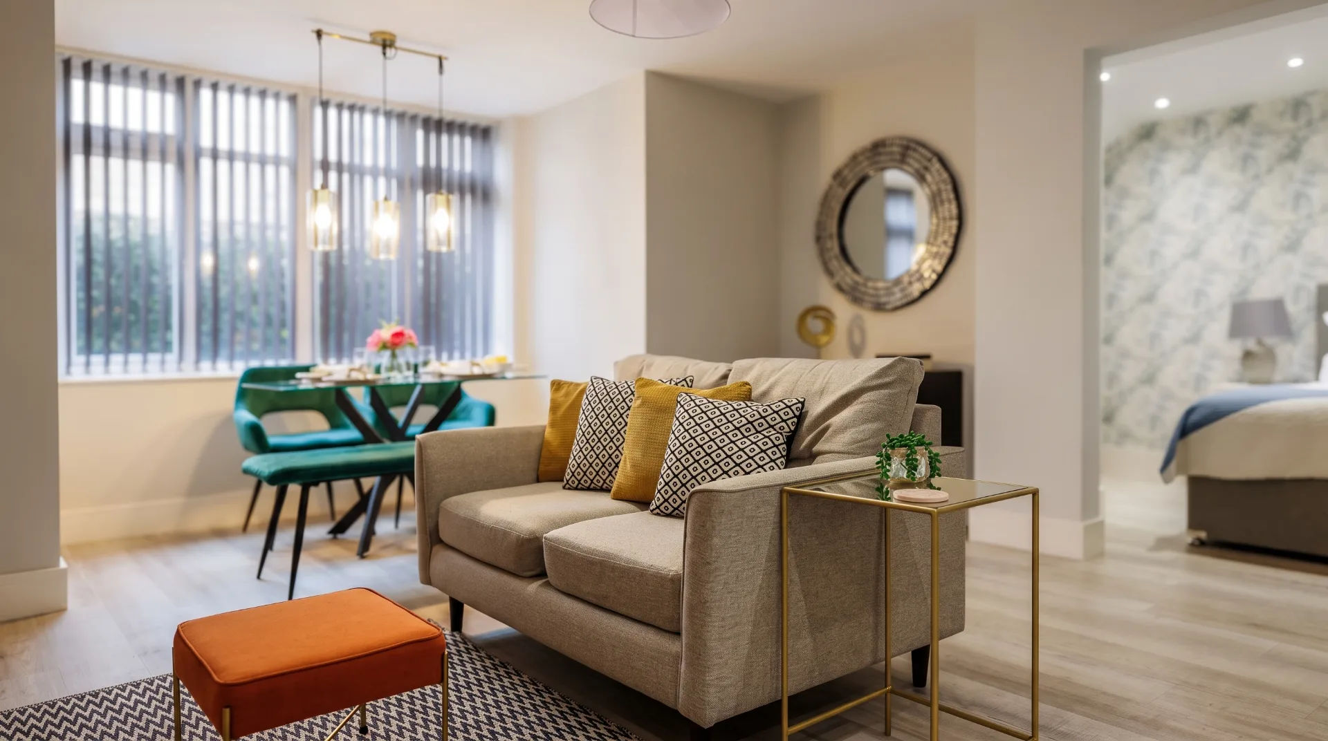Modern living area with a sofa, decorative cushions, dining table, and stylish lighting in Seabreeze Apartments