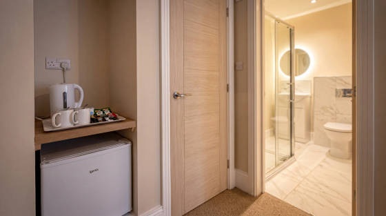 Corner of a hotel room showing kitchenette and bathroom