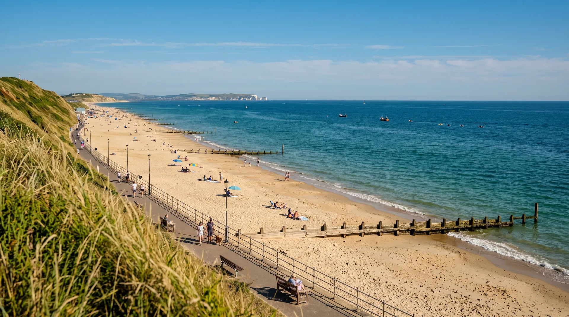A sunny Southbourne beach scene with people relaxing on the sand and walking along the promenade.