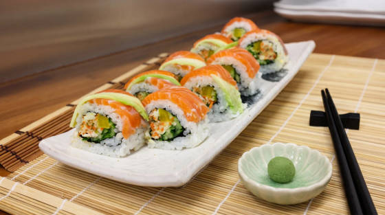 Sushi rolls with salmon and avocado on a white plate