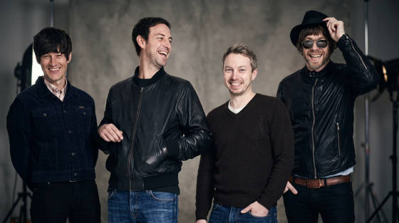 Four men smiling and posing in casual clothing