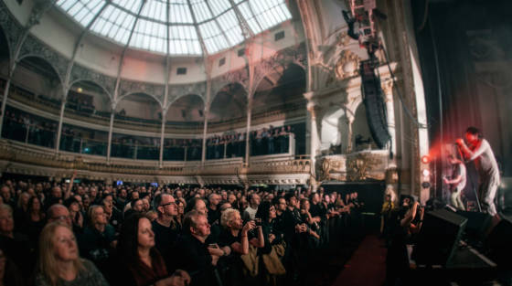 Crowd watching a live performance in an ornate concert hall