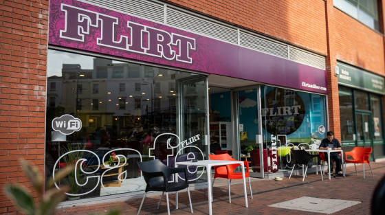 Outdoor seating area of Flirt Café with a customer at a table