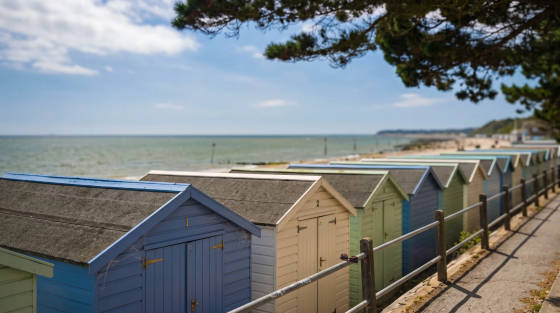 Row of colourful beach huts with the sea in the background