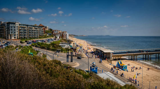 Bournemouth beach with pier, buildings and people enjoying the sun