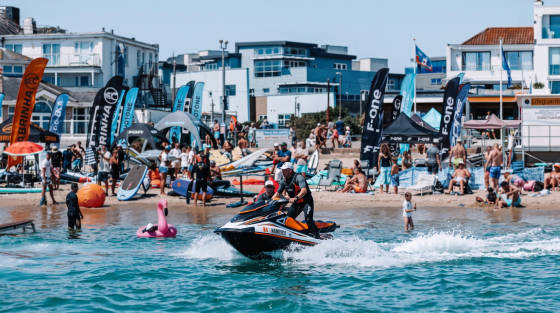 A jet ski on the water with beachgoers in the background