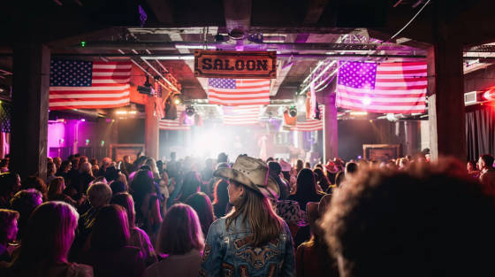 A lively crowd at a venue decorated with American flags