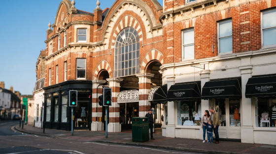 Red brick building with boutique shops and pedestrians