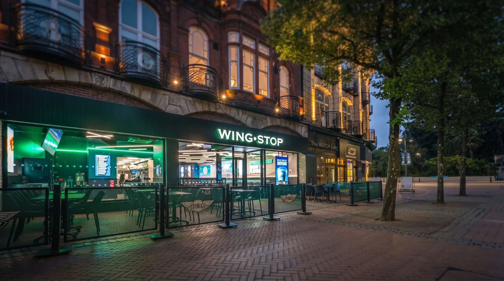 Wingstop restaurant exterior in The Square, Bournemouth, with green lighting and outdoor seating area