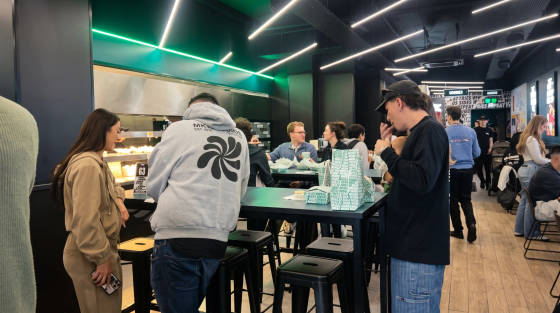 Interior of a bustling food venue with customers at tables