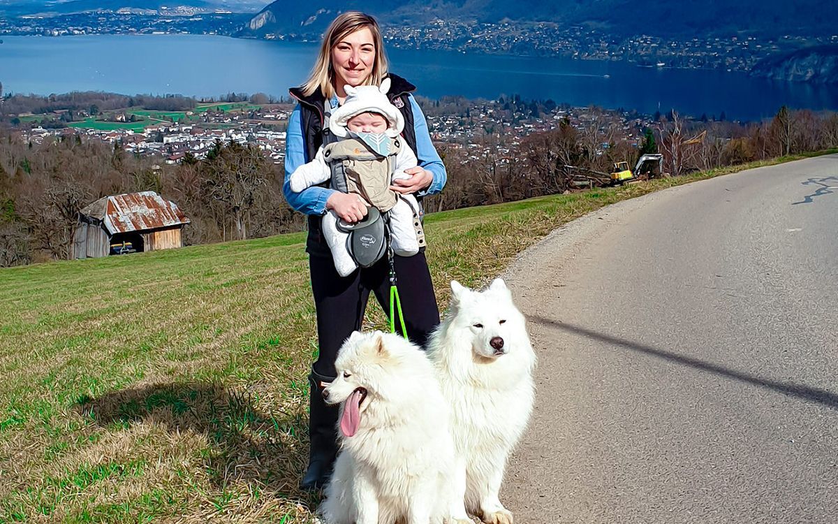 femme devant le lac d'Annecy avec son bébé et 2 chiens