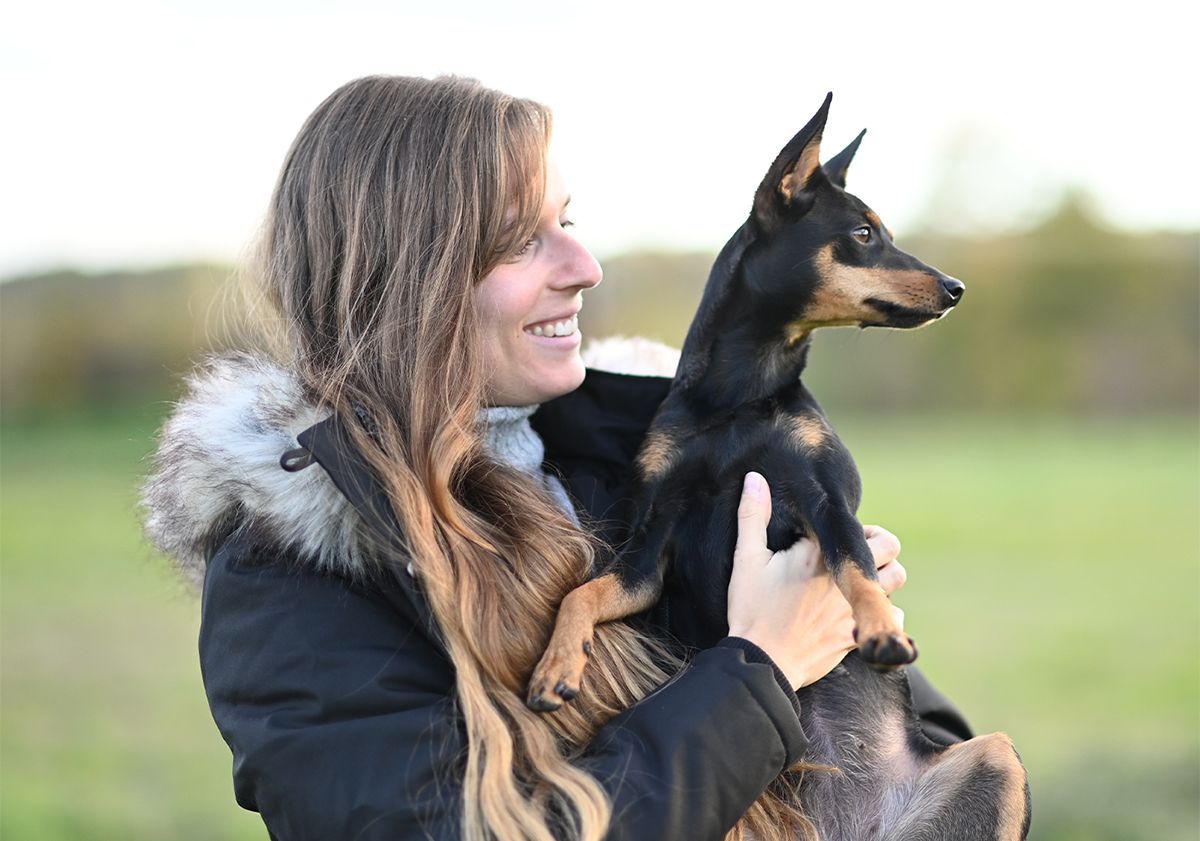 Un Pinscher et sa maîtresse regardant dans la même direction