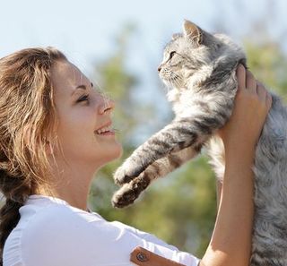 Une femme portant son chat 