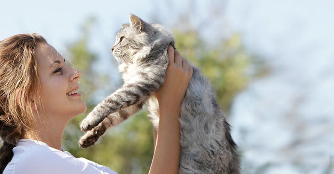 Une femme portant son chat 