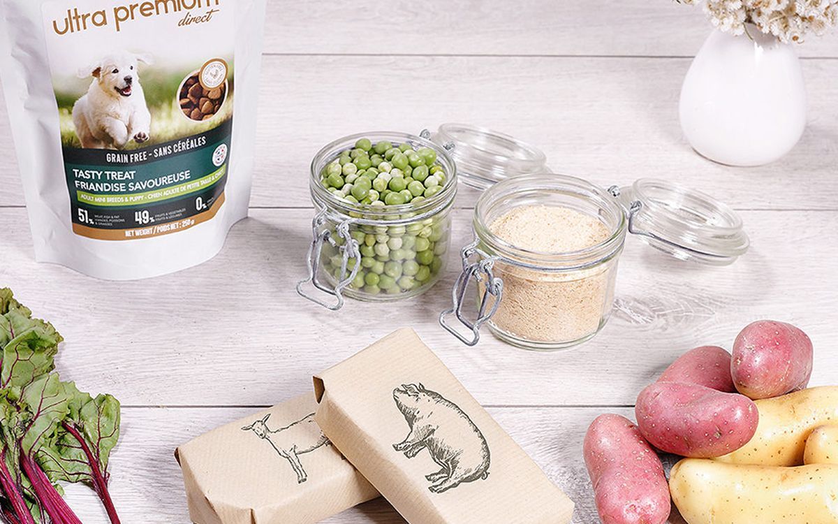 Plusieurs éléments disposés sur une table : des pommes de terre, des légumes ainsi qu'une friandise Ultra Premium Direct