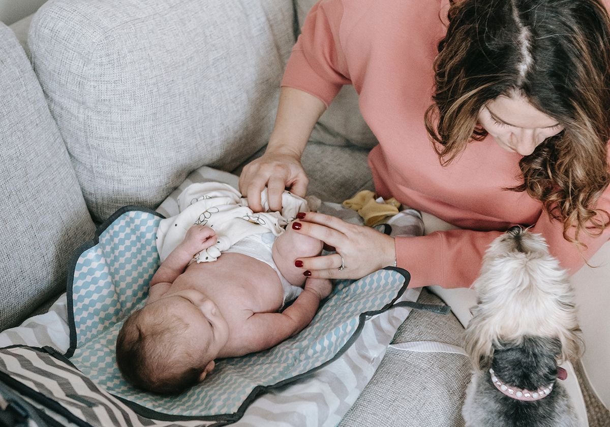 Mère changeant son enfant avec son chien à proximité