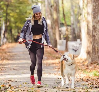 Une femme courant avec son chien dans un parc