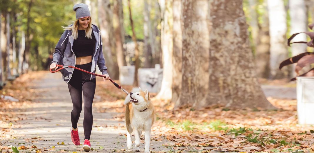 Une femme courant avec son chien en pleine nature