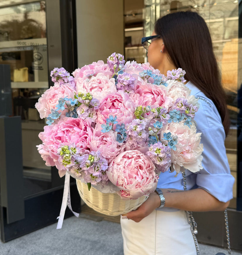 Arrangement of peonies and mattiola in a basket