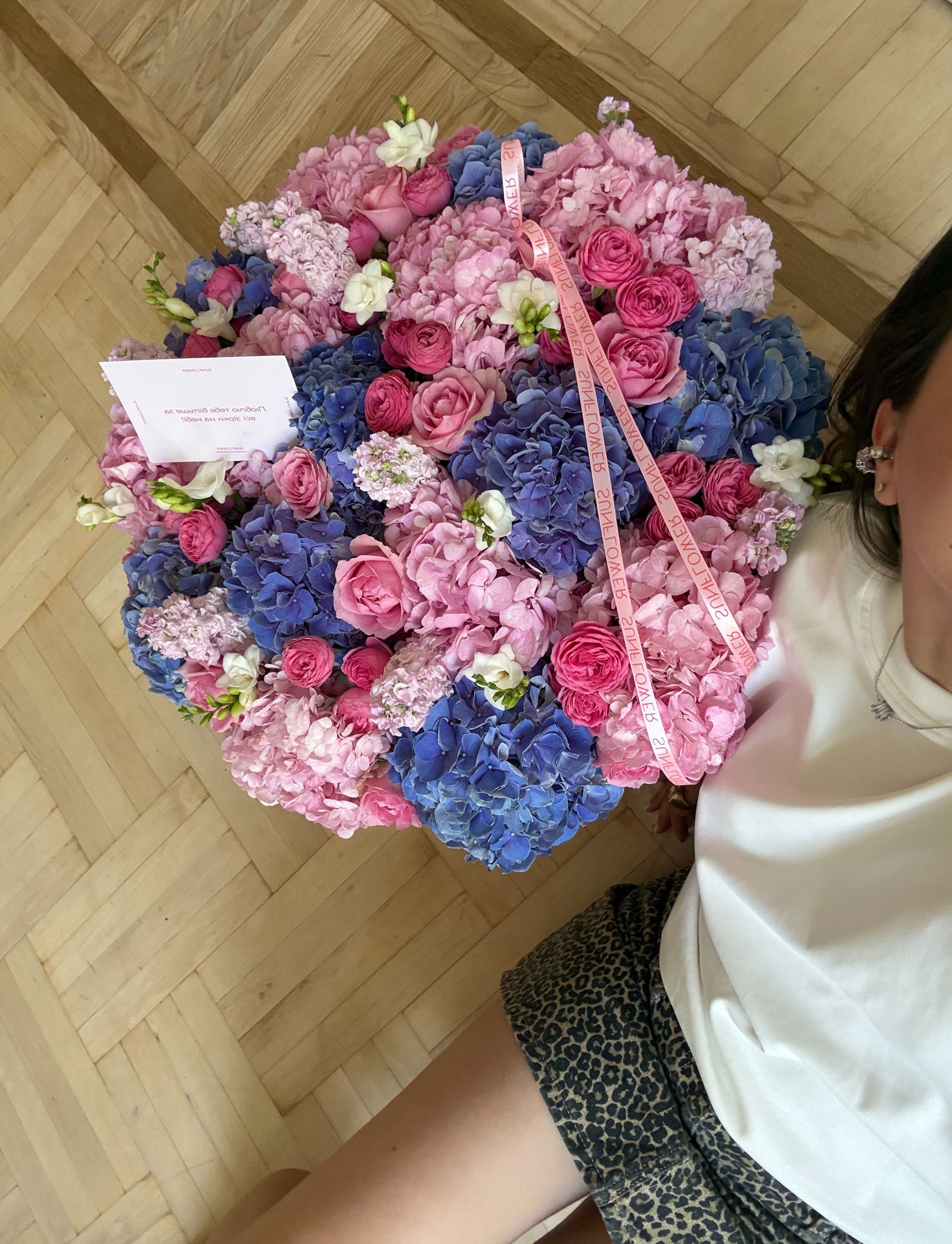 Arrangement in a basket with blue hydrangeas and roses