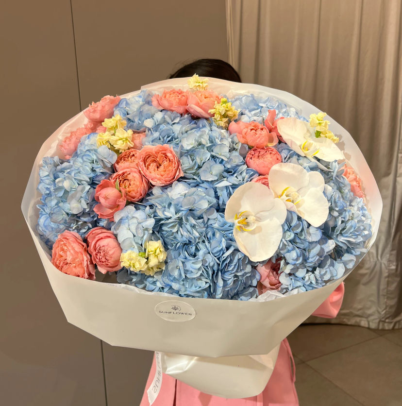 Bright bouquet mix of blue hydrangea and roses
