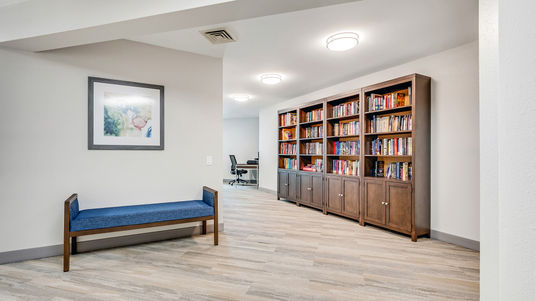 Library with bookshelves and sitting bench at Holiday Palmer Hills