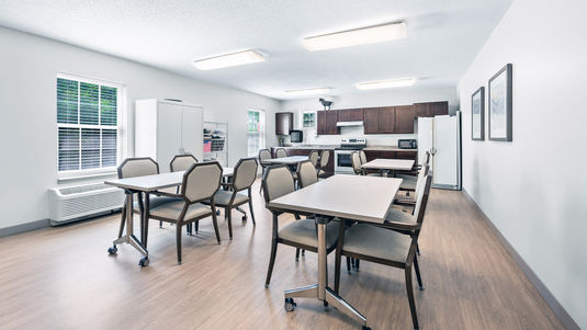 Multipurpose room with rectangular tables and a resident kitchen