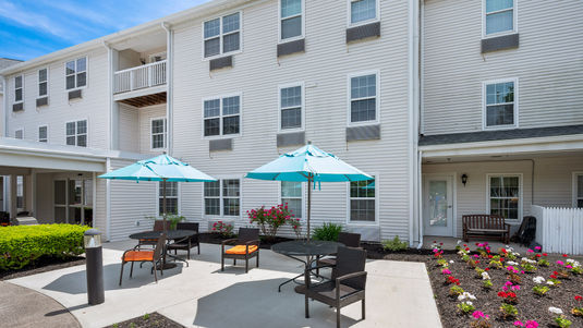Community patio with furniture and large teal umbrellas