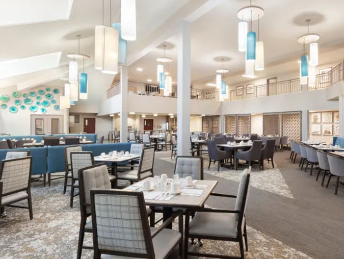 Brightly lit dining room with an array of tables and chandeliers displayed throughout