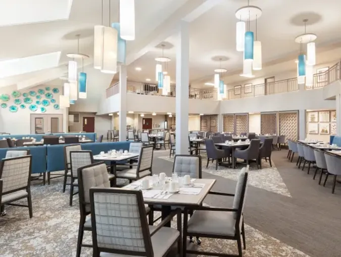 Brightly lit dining room with an array of tables and chandeliers displayed throughout