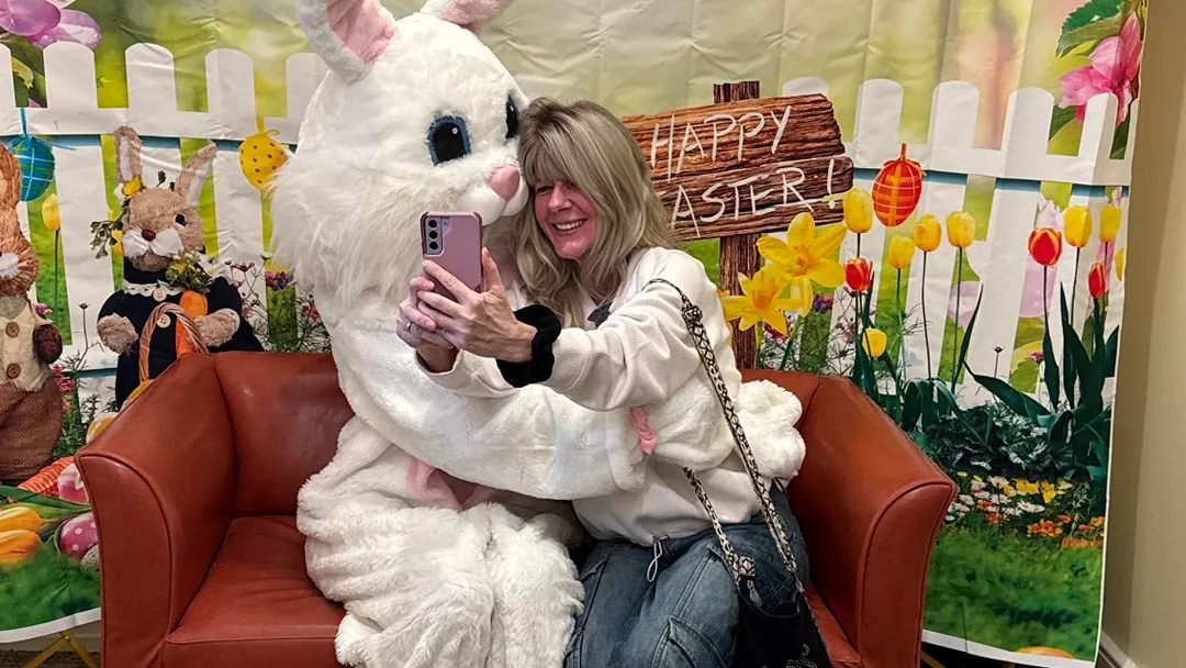 Residents enjoy taking pictures with the Easter Bunny that visited the community