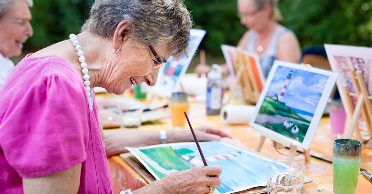 Atria Senior Living residents outside and painting together