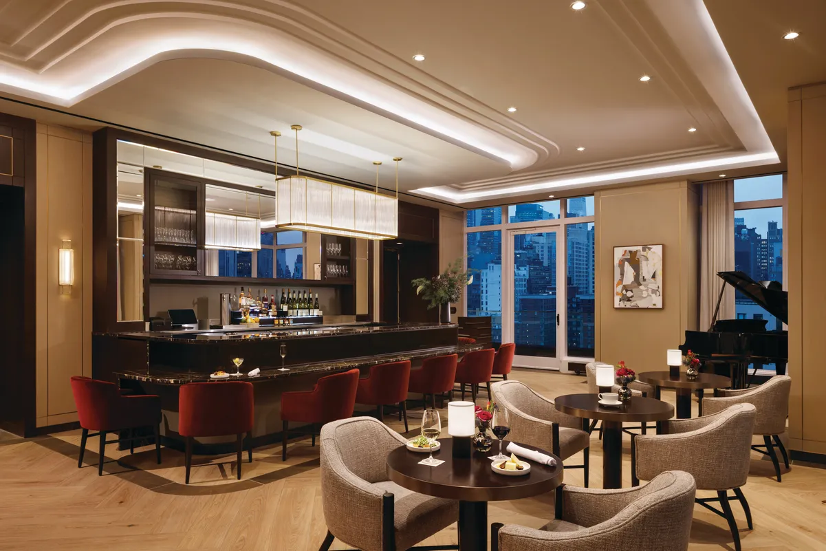 Lounge with a bar, piano and bar tables.