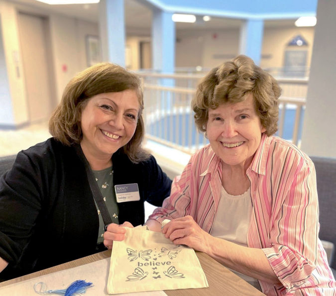 senior woman participating in community events alongside staff