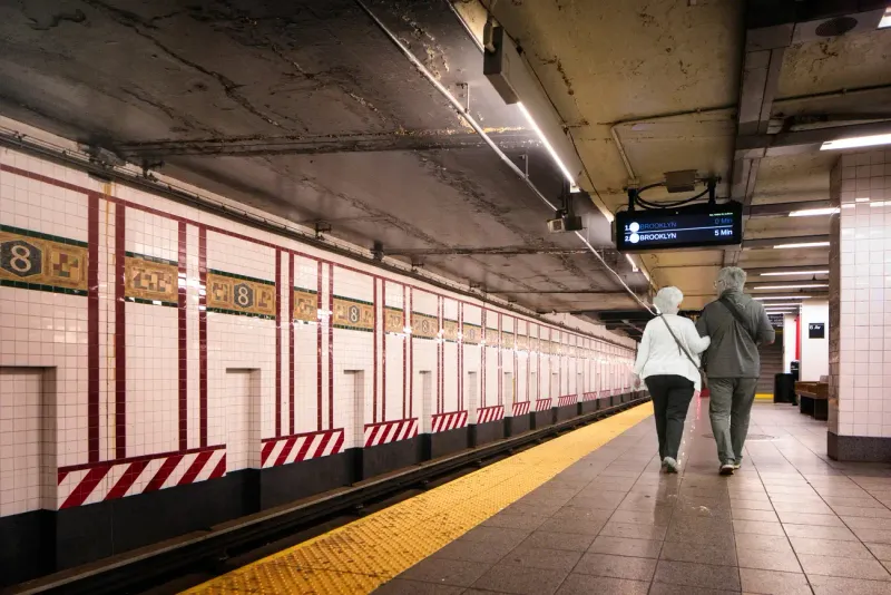 Older couple walking arm in arm at the NYC subway