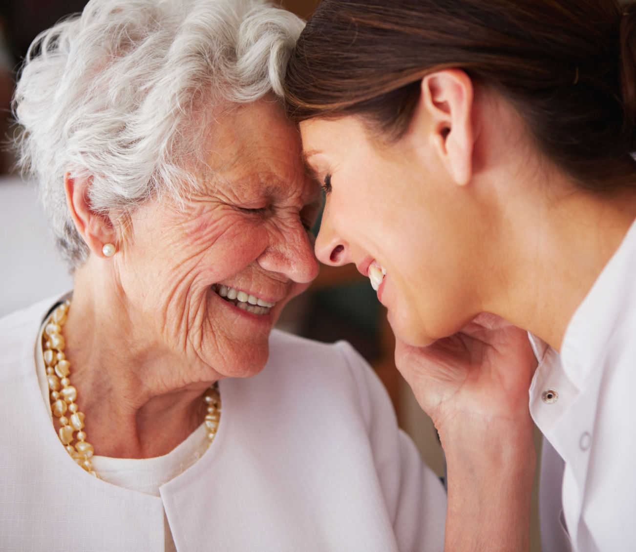 Older woman and daughter smiling and laughing together