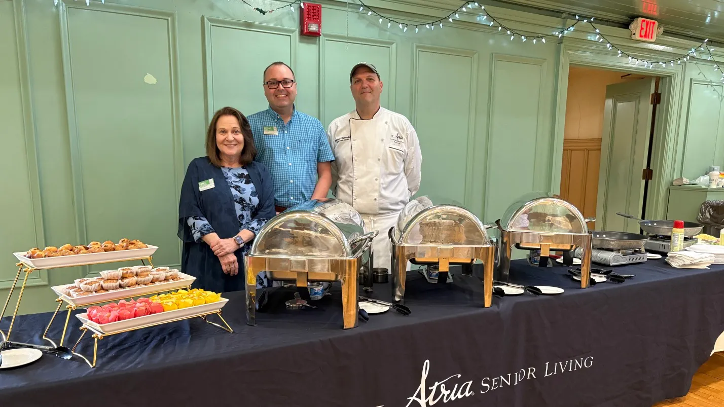 Chef and staff standing next to the meal made for a recent event