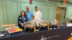 Chef and staff standing next to the meal made for a recent event