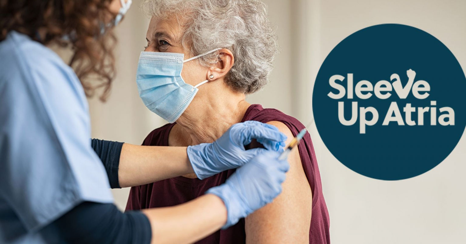 Older woman receiving a vaccine from a nurse