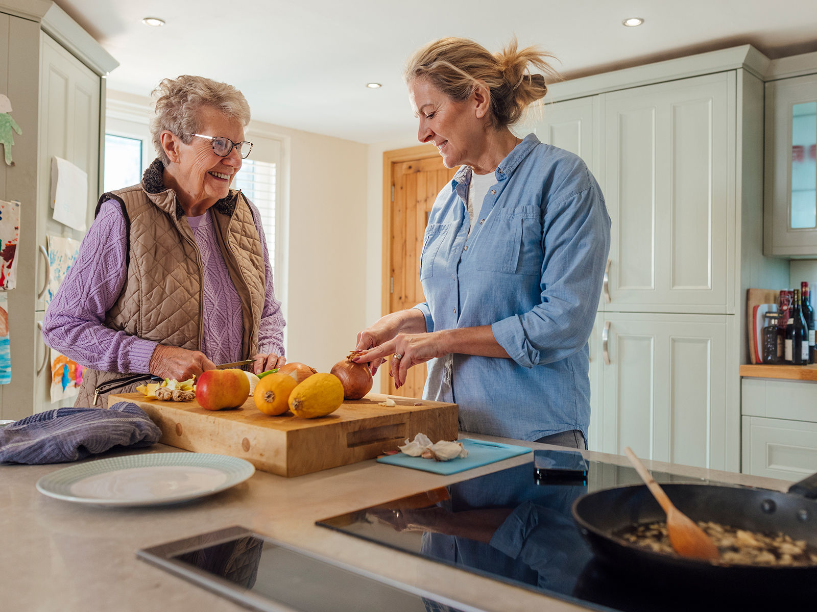 senior mother and daughter preparing lunch together