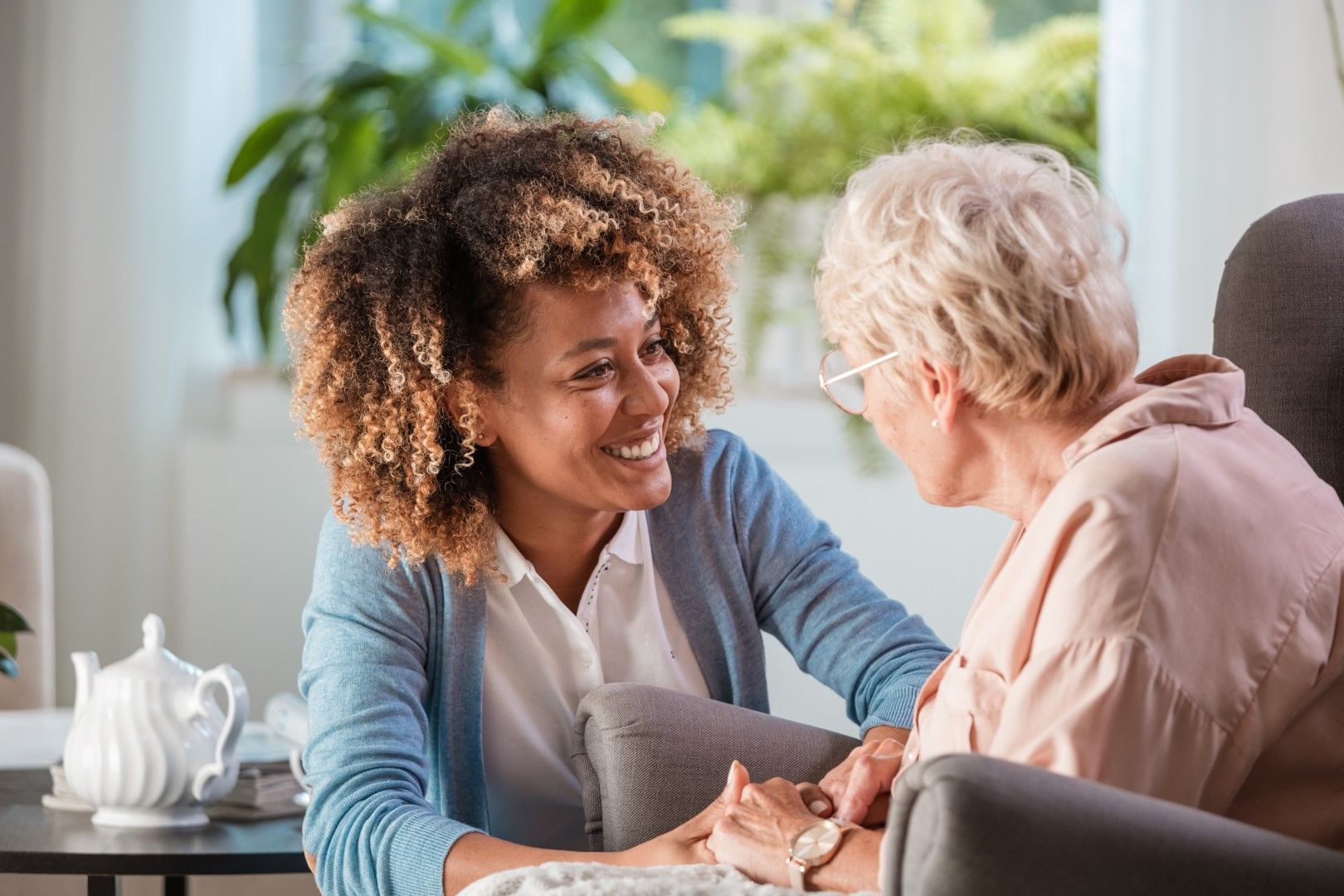 Senior woman sitting and talking with caregiver