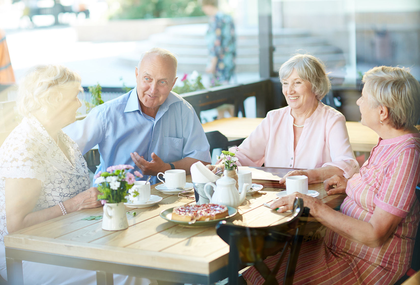 4 senior living residents eating a pizza at a resturant