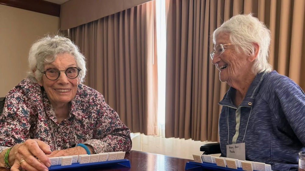 two female senior residents sitting together in a hotel room recounting their experience, escaping the Palisades Fire
