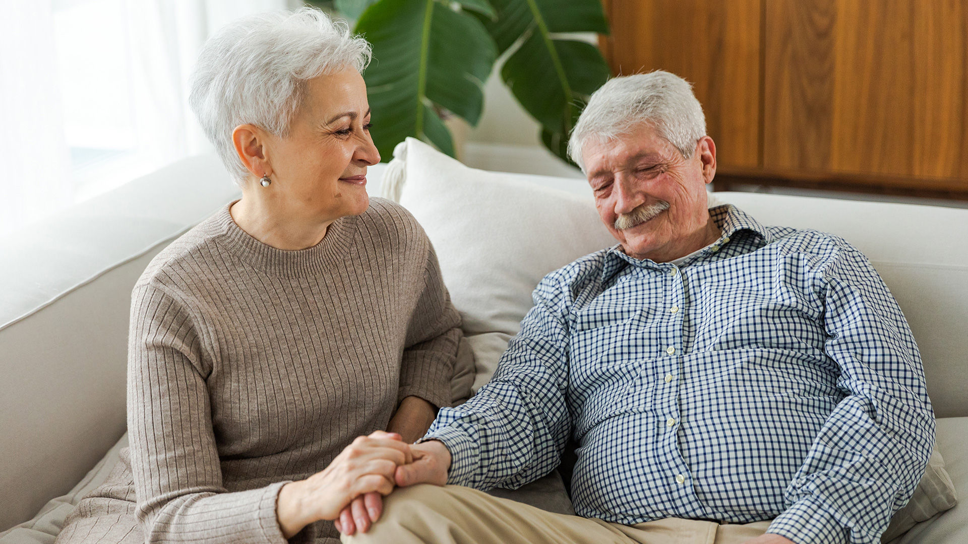senior husband and wife relaxing on the couch together