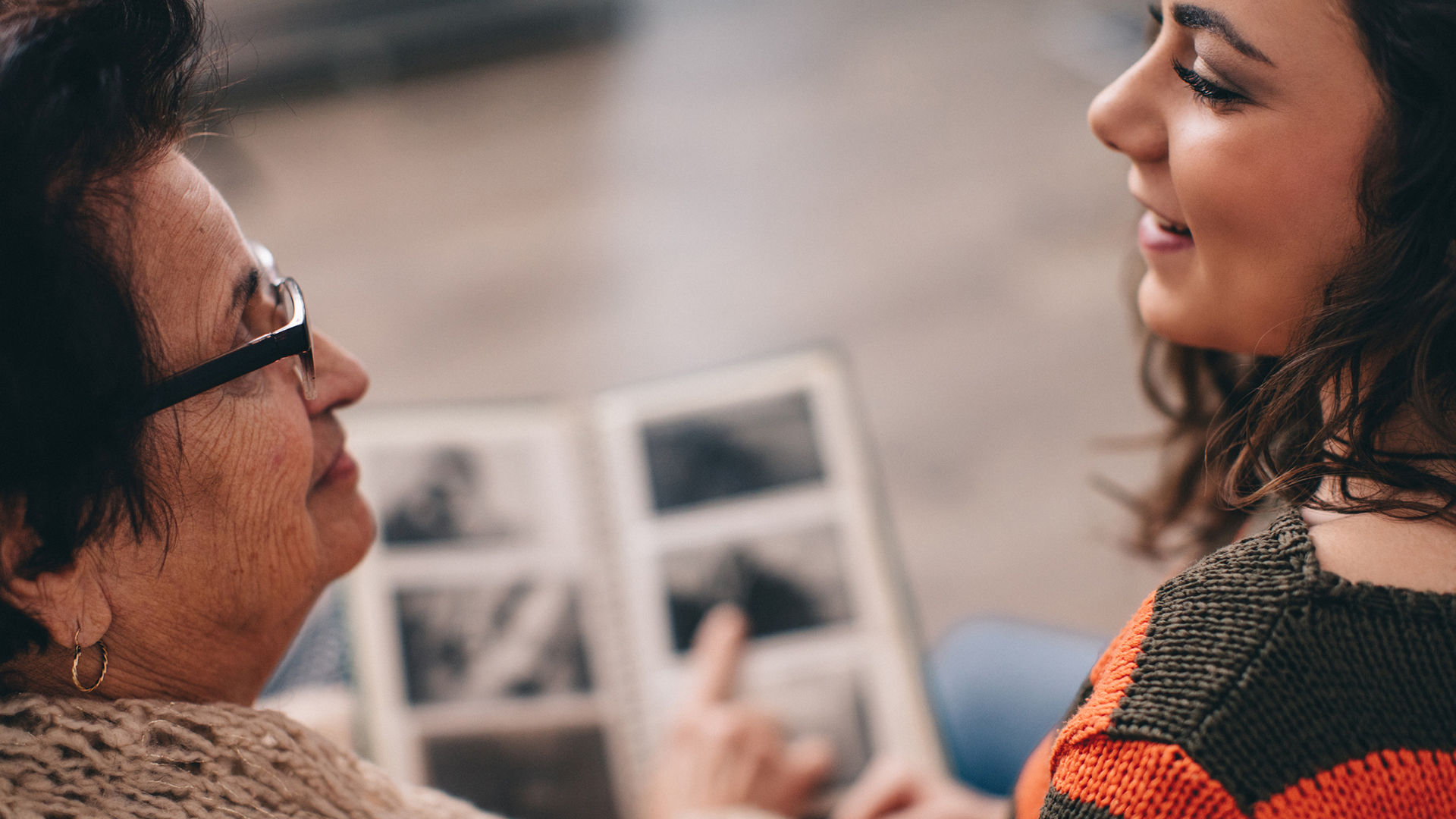 Senior woman and granddaughter looking at old photos