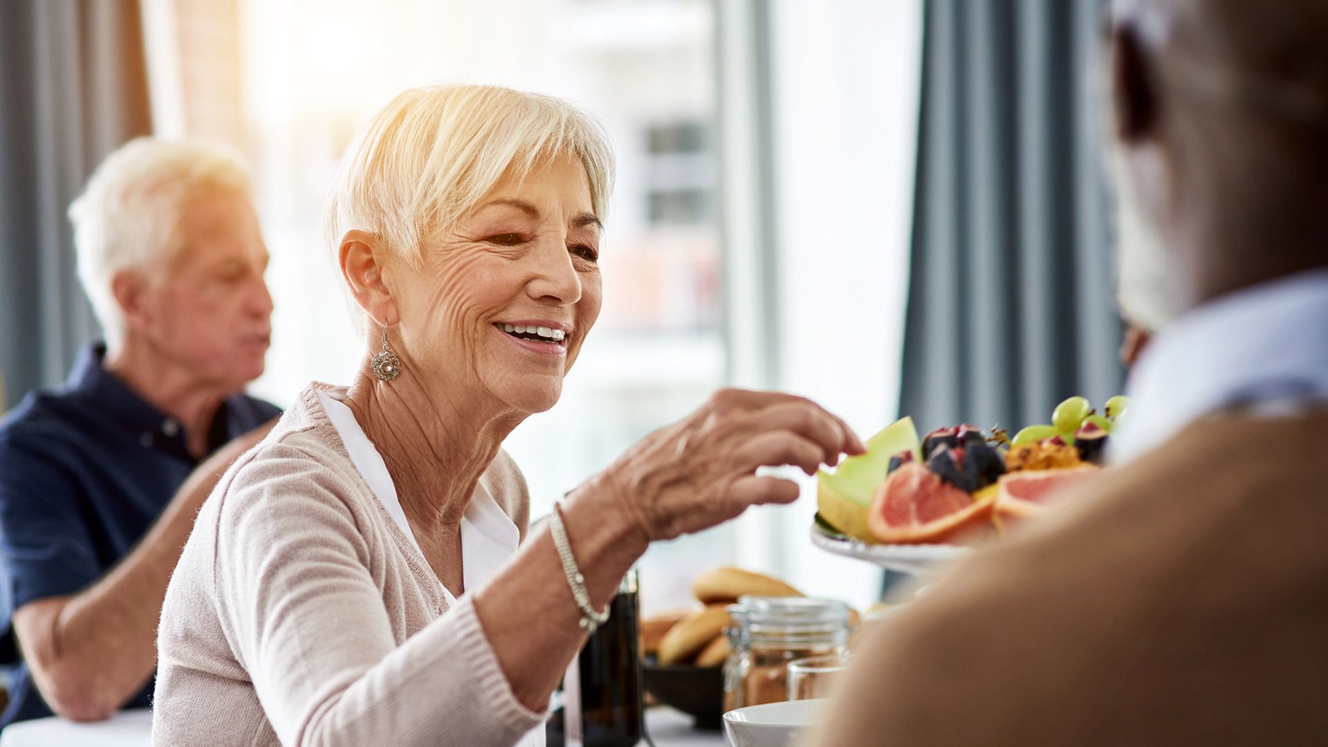Shot of a cheerful group of senior people talking and enjoying breakfast together at home