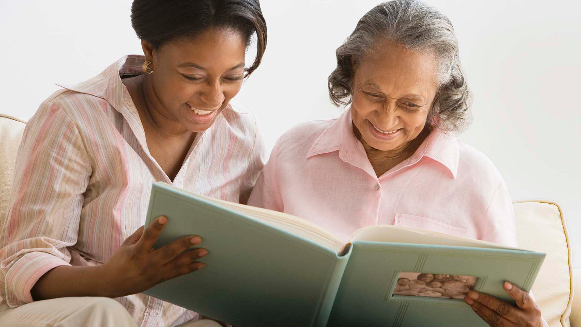 Senior mother and daughter looking at photo album together