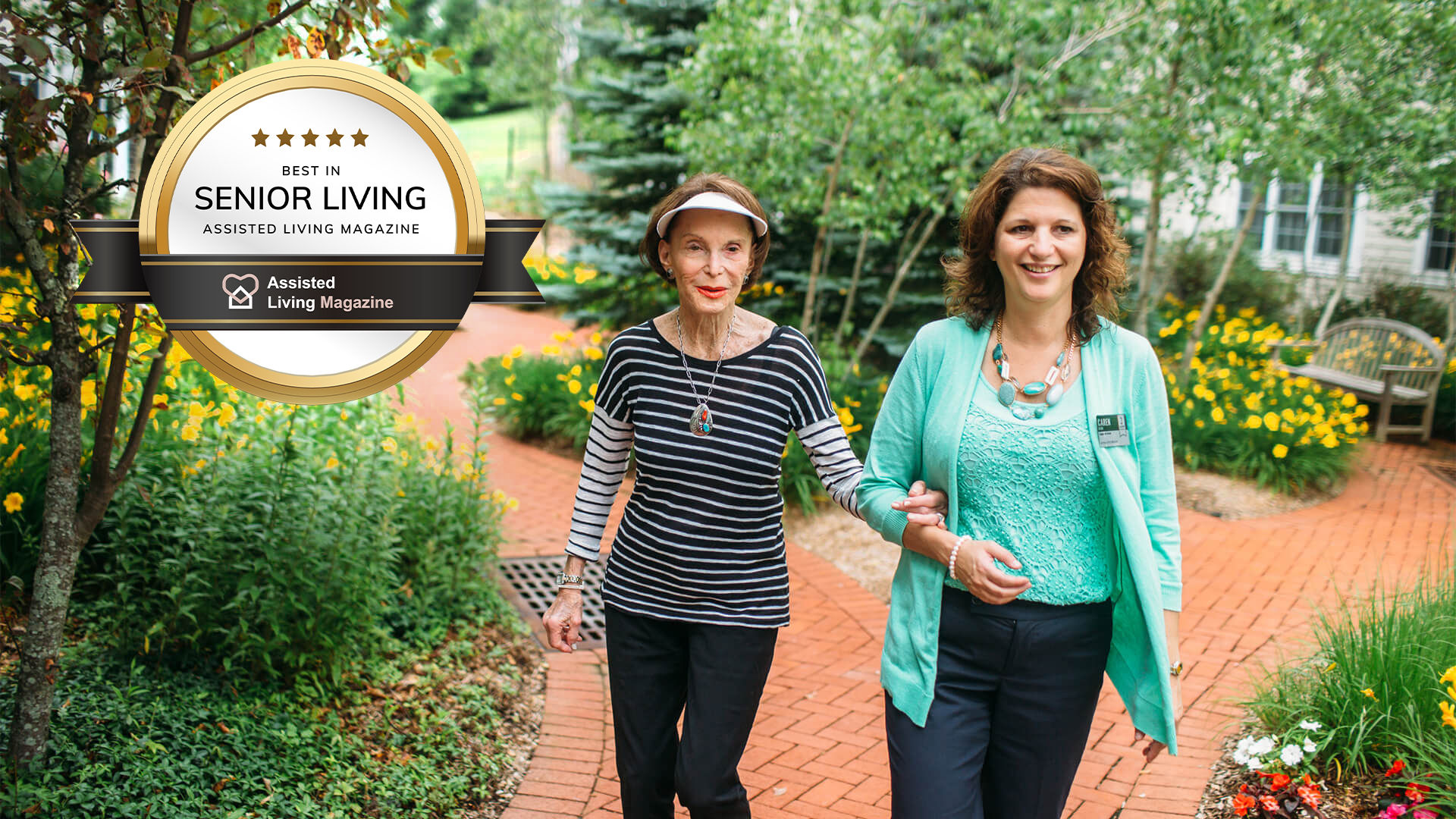 Senior resident and staff member walking in courtyard. AL Magazine badge in upper left hand corner.