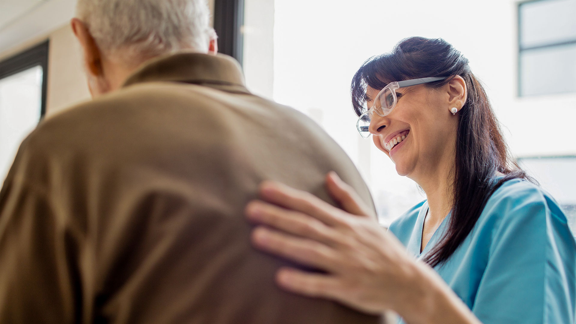 friendly assisted living staff member helps resident prepare for the day